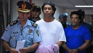 Brazilian retired football player Ronaldinho (C) and his brother Roberto Assis (R) arrive at Asuncion's Justice Palace to appear before a public prosecutor who will decide whether to grant them bail or not following their irregular entry to the country, i