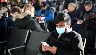 A man wears a surgical mask as he sits in Terminal 5 at Heathrow Airport in London, Britain March 6, 2020. REUTERS/Hannah McKay