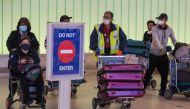 Passengers wear face masks to protect against the COVID-19 (Coronavirus) after arriving at the LAX airport in Los Angeles, California on March 5, 2020. California has declared a state of emergency as the number of novel coronavirus cases and deaths in the