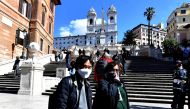 Tourists wearing protective masks visit Piazza di Spagna in Rome on March 8, 2020. AFP / Tiziana FABI
