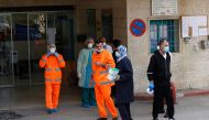 Palestinian staff stand at the emergency entrance of Beit Jala Hospital on March 9, 2020, near the West Bank city of Bethlehem which is under lockdown due to the novel coronavirus epidemic. AFP / Musa Al Shaer
 