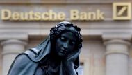A statue is seen next to the logo of Germanys Deutsche Bank in Frankfurt, January 26, 2016. Reuters /  Kai Pfaffenbach