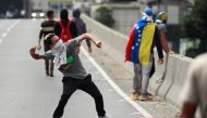 A demonstrator throws a rock during a protest in Caracas, Venezuela March 10, 2020. Reuters/Carlos Jasso 
 