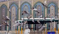 A worker in a protective suit sprays disinfectants near Imam Abbas shrine as a precaution against the coronavirus, following the outbreak, in the holy city of Kerbala, Iraq March 15, 2020.REUTERS/Abdullah Dhiaa Al-deen 