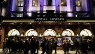 Theatre-goers wearing masks arrive for an evening show of 