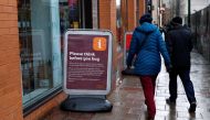 People walk past a sign warning customers of product shortages outside a Sainsbury's Local supermarket in central Birmingham, Britain, March 15, 2020 . REUTERS/Andrew Boyers
