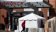 A tent is erected for screening people with flu-like symptoms, in connection with the coronavirus pandemic outside the South Shore Hospital's emergency department in Weymouth, Mass. Photo by Adam Glanzman for The Washington Post
