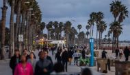 People walk on the beach twenty minutes after the California Governor Gavin Newson issued a statewide order to people stay home in Santa Monica, California on March 19, 2020. / AFP / Apu GOMES