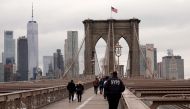 :NEW YORK, NEW YORK, - MARCH 17: A New York City Police officer looks on from the Brooklyn Bridge as it sees significantly less traffic due to coronavirus cases and fears on March 17, 2020 in New York City. Justin Heiman/AFP 