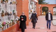 People wearing face masks arrive at the South Municipal cemetery in Madrid, on March 23, 2020, to attend the burial of a man who died of the new coronavirus./ AFP / BALDESCA SAMPER
