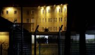 Members of ERIES, the Regional Response and Security Team, stand ready to intervene at the detention centre of Uzerche, central France, as inmates gathered on the roof of the prison, on March 22, 2020, after visiting hours for families and relatives of th