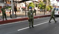 Philippine policemen wearing facemasks man a checkpoint after the government imposed an enhanced quarantine as a preventive measure against the COVID-19 novel coronavirus in Manila on March 25, 2020. / AFP / Ted ALJIBE