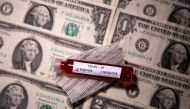 Test tube with fake blood labelled with the coronavirus disease (COVID-19) is placed on dollar banknotes in this illustration taken March 27, 2020. Reuters/Dado Ruvic