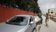 Jordanian soldiers check a car as they guard a check point in the northern governorate of Irbid, as the city has been isolated and people were banned from entering it, after the number of coronavirus disease (COVID-19) cases have increased in the area, Ir