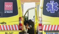 An ambulance driver wearing a protective face mask and suit takes a break near the emergency unit at 12 de Octubre hospital during the coronavirus disease (COVID-19) outbreak in Madrid, Spain March 28, 2020. REUTERS/Sergio Perez 