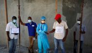 Medical staff display signs after the director of the hospital, surgeon Jerry Bitar, was kidnapped, as Haiti battles COVID-19 outbreak amid a spike in gang violence, in Port-au-Prince, Haiti March 27, 2020. The sign on right says the hospital will reopen 
