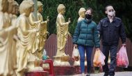 Family members wearing face masks, for protection against the coronavirus disease (COVID-19), carry fruits to pay their respects to their loved ones for tomb-sweeping festival at a columbarium in Taipei, Taiwan, March 29, 2020. REUTERS/Ann Wang