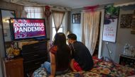Undocumented immigrant Juana, 24, from El Salvador and her husband Saul, 23, from Honduras watch local news in their one-room apartment on March 25, 2020 in Norwalk, Connecticut. John Moore/Getty Images/AFP
 