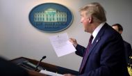 U.S. President Donald Trump holds a letter from White House physician Commander Sean Conley that reports that the president has tested negative a second time for coronavirus disease during a use of the new 15-minute result test at the White House in Washi