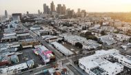 LOS ANGELES, CALIFORNIA - APRIL 04: An aerial view of mostly empty streets and parking lots with the downtown skyline in the background amid the coronavirus pandemic on April 4, 2020 in Los Angeles, California. Mario Tama/AFP
