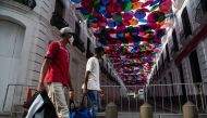 CARACAS, Venezuela - APRIL 02: Two men pass by a down town street covered with umbrellas which is empty as a preventive measure against the new type of coronavirus (COVID-19) pandemic in Caracas, Venezuela on April 02, 2020. ( Carolina Cabral Fernandez - 