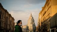 A woman wearing a face mask walks in a deserted street in central Moscow on April 13, 2020 during a strict lockdown in Russia to stop the spread of the COVID-19, caused by the novel coronavirus.  / AFP / Dimitar DILKOFF