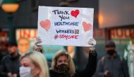 :NEW YORK, USA - APRIL 12: A woman holds a 'Thank You' sign for healthcare workers who risk their lives to serve for new type of coronavirus (COVID-19) patients in New York City, United States on April 12, 2020. ( Tayfun Co?kun - Anadolu Agency )
