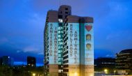 :A projection from a private house illuminates the facade of the Barcelona Hospital reading 