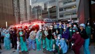 Healthcare workers pose for pictures together outside NYU Langone Medical Center on 1st Avenue in Manhattan as New York Police Department (NYPD) Mounted Police and other units came to cheer and thank healthcare workers at 7pm during the outbreak of the co