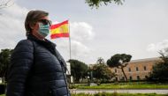 A woman wearing a medical mask walks at nearly empty Columbus Square after precautions against the spread o in Madrid, Spain on April 17, 2020. Burak Akbulut - Anadolu 