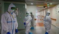 TOPSHOT - Medical workers wearing protective equipment walk in a hall of Moscow's K+31 private hospital, which has switched over entirely to treating coronavirus patients, on April 20, 2020. / AFP / Dimitar DILKOFF