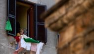 A resident in the Garbatella district of Rome takes part on April 25, 2020 in a 'Liberation Day' flashmob with people singing Italian partizan song 'Bella Ciao' from their window or balcony, during the country's lockdown aimed at curbing the spread of the