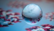 A globe showing the continents of North and South America is pictured on an illustration representation of COVID-19, the disease caused by the novel coronavirus in Paris on April 24, 2020. / AFP / JOEL SAGET