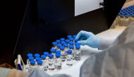 A lab technician inspects filled vials of investigational coronavirus disease (COVID-19) treatment drug remdesivir at a Gilead Sciences facility in La Verne, California, U.S. March 11, 2020. Picture taken March 11, 2020. Gilead Sciences Inc/Handout via RE