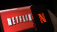 (FILES) In this file illustration photo taken on March 31, 2020 a computer screen and mobile phone display the Netflix logo in Arlington, Virginia. While coronavirus has brought Hollywood to a halt, Netflix has enjoyed record success. But will the streami