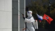 A municipal worker wearing a protective suit disinfects an office building in Moscow, on May 1, 2020 during a partial lockdown amid the COVID-19 outbreak caused by the novel coronavirus. / AFP / Vasily MAXIMOV