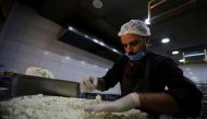 A worker prepares a traditional sweet 