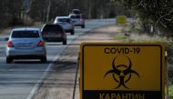 Cars drive past a sign reading 'COVID-19 Quarantine' on a road towards Pervomayskoye settlement during the coronavirus disease (COVID-19) outbreak in Leningrad Region, Russia May 5, 2020. REUTERS/Anton Vaganov