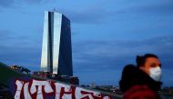 FILE PHOTO: A woman, wearing a protective mask walks past the head quarter of the European Central Bank (ECB) during sunset in Frankfurt, Germany, April 29, 2020, as the spread of the coronavirus disease (COVID-19) continues. REUTERS/Kai Pfaffenbach/File 