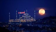 The full moon, also known as the Supermoon or Flower Moon, rises above the Camlica Mosque during the spread of the coronavirus disease (COVID-19), in Istanbul, Turkey, May 7, 2020. REUTERS/Umit Bektas