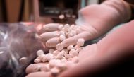 An employee of a pharmaceutical factory shows pills of the hydroxychloroquine drug, used to prevent or cure COVID-19, on April 28,2020  / AFP / LOUAI BESHARA