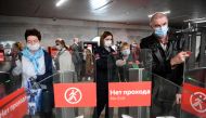 People wearing face masks walk through ticket gates at Savyolovskaya metro station on the first day of mandatory use of masks and gloves on Moscow public transport, in Moscow on May 12, 2020, amid the coronavirus pandemic. / AFP / Kirill KUDRYAVTSEV
