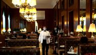 A waiter serves coffee at Cafe Landtmann during the global coronavirus disease (COVID-19) outbreak in Vienna, Austria, May 15, 2020. REUTERS/Lisi Niesner
