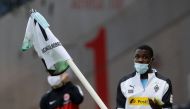 Moenchengladbach's French forward Marcus Thuram carries the corner flag after the German first division Bundesliga football match Eintracht Frankfurt v Borussia Moenchengladbach on May 16, 2020 in Frankfurt, western Germany as the season resumed following