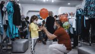 A Qatar Charity official giving Eid Al Fitr gifts to a child in Indonesia.
