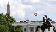 Flags fly at half-staff on the White House to commemorate the victims of the coronavirus disease (COVID-19) in Washington, U.S., May 23, 2020. REUTERS/Mary F. Calvert