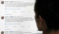 TOPSHOT - This illustration photo shows an editor in Los Angeles looking at the official Twitter account of US President Donald Trump on May 26, 2020, with two tweets by the president under which Twitter posted a link reading 