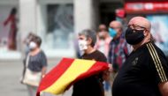 People wearing protective face masks stand during a daily minute of silence to commemorate victims of the coronavirus disease (COVID-19), at Puerta del Sol square in Madrid, Spain, May 26, 2020. REUTERS/Sergio Perez
