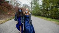 Caroline Afonso and MK Rusnock, high school seniors graduating from Ursuline Academy, walk through the Arnold Arboretum while posing for photographs for Reuters in their prom dresses, after prom was cancelled due to the coronavirus disease (COVID-19) outb