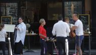 People stand and drink outside a cafe in Paris on May 29, 2020, ahead of the re-opening of the French capital's cafe terraces, scheduled for June 2, as France eases lockdown measures taken to curb the spread of the COVID-19 pandemic, caused by the new cor